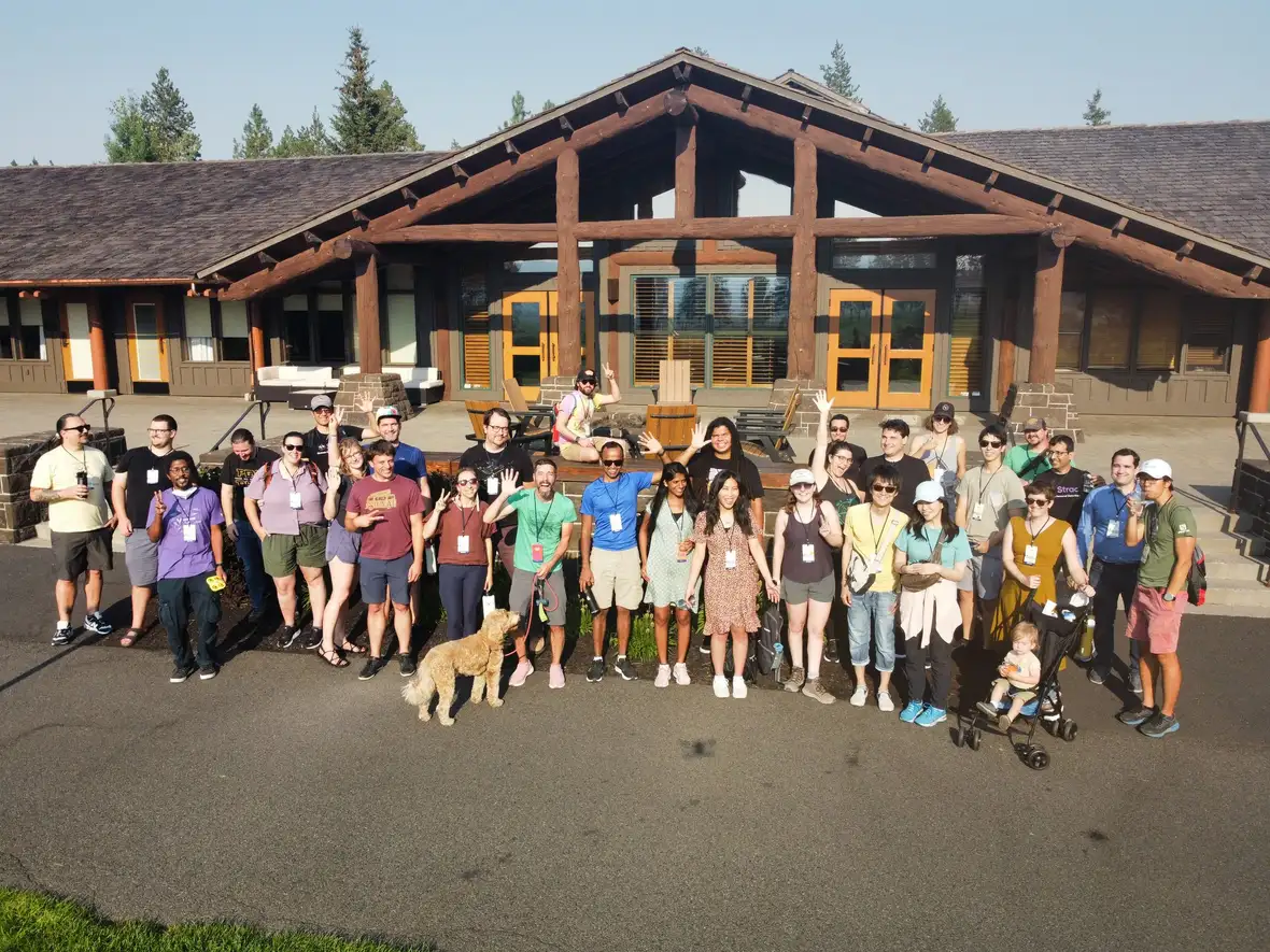 Conference attendees standing in front of a venue on a sunny day
